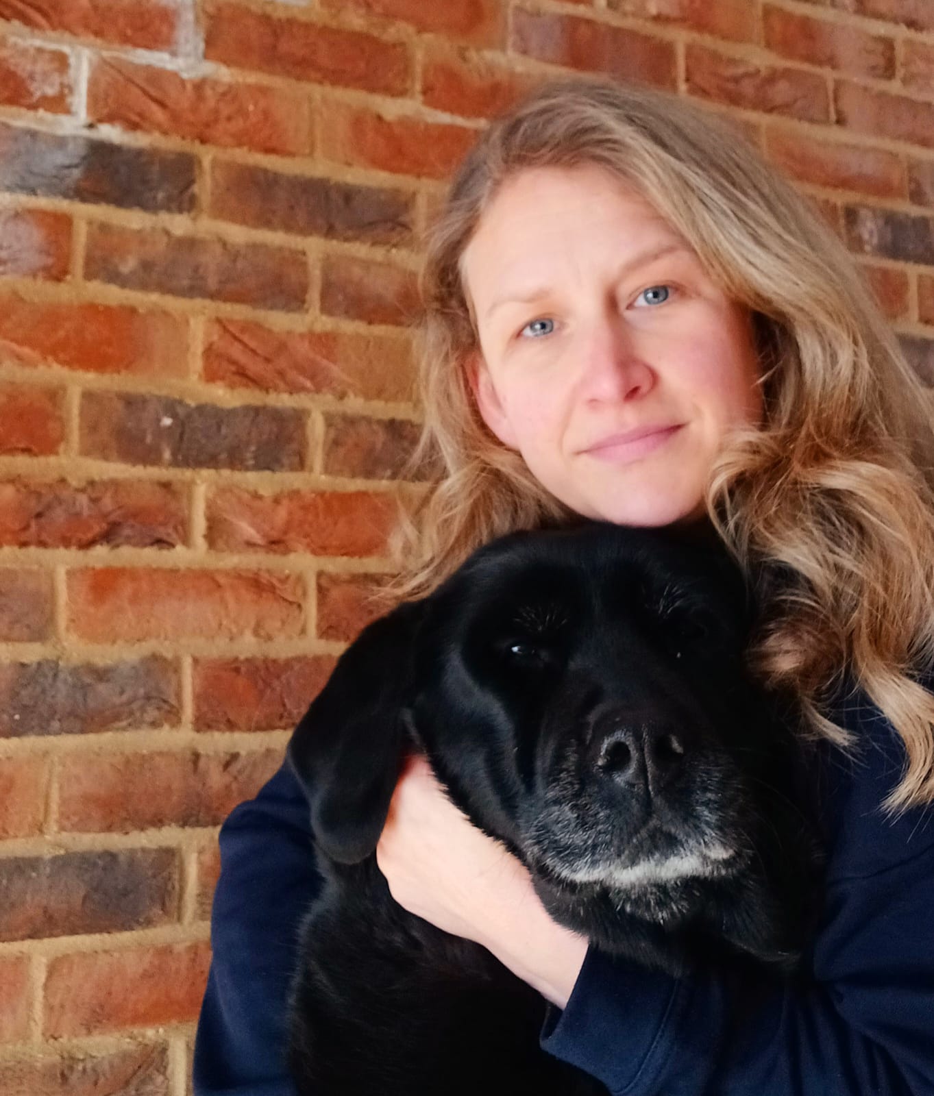 Corinne Swayne Humanimal Trust Fundraising Officer with her dog Holly a black labrador
